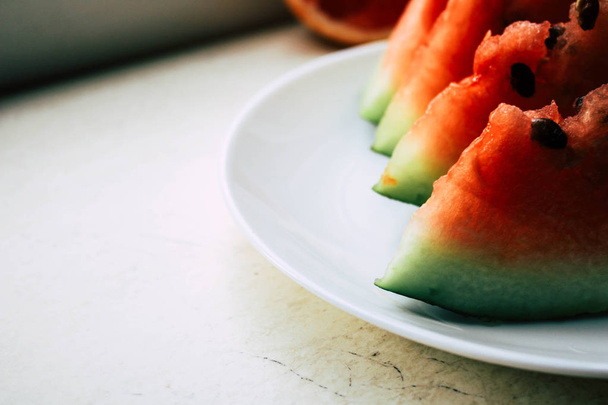 Wassermelone in Scheiben geschnitten auf einem weißen Teller - Foto, Bild