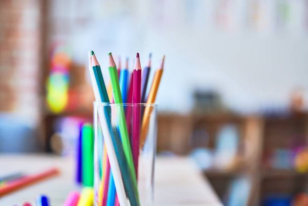 Escritorio con un montón de lápices de colores y pluma para dibujar en el jardín de infantes
 - Foto, Imagen