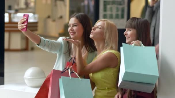 γυναικεία shopaholism, χαρούμενη φίλες τραβήξτε φωτογραφίες στο κινητό τηλέφωνο, ενώ ψώνια με πακέτα στα χέρια κατά τη διάρκεια της περιόδου πωλήσεων και εκπτώσεις για το μαύρο Παρασκευή - Πλάνα, βίντεο