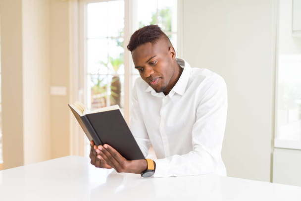 Молодой африканский человек, читающий книгу, готовящийся к универсальности
 - Фото, изображение