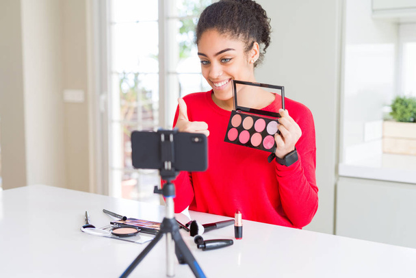 Young african american influencer woman recording make up tutorial happy with big smile doing ok sign, thumb up with fingers, excellent sign - Fotoğraf, Görsel