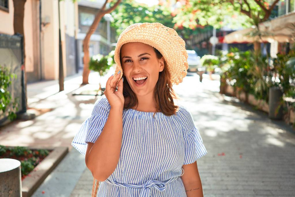 junge schöne Frau lächelt glücklich zu Fuß auf den Straßen der Stadt an einem sonnigen Sommertag - Foto, Bild
