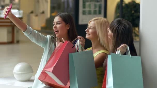 Mutlu alışverişler, şirket müşterisi kadınlar, satış sezonunda ellerinde paketler ve indirimlerle alışveriş yaparken telefonla selfie çekiyorlar. - Video, Çekim