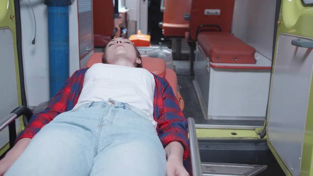 Donna malata sdraiata sulla barella in auto ambulanza
. - Foto, immagini
