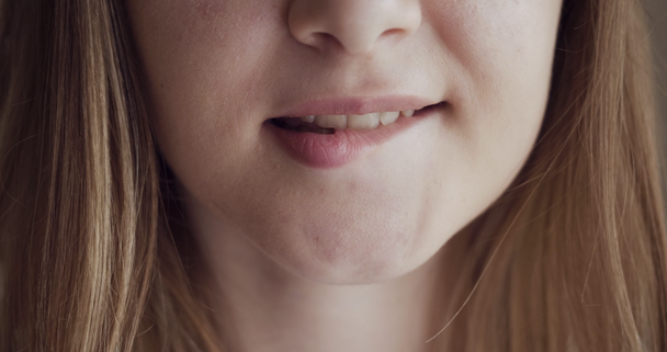 Mädchen beißt Lippen und lächelt mit schönen weichen Lippen. - Filmmaterial, Video