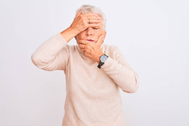 Senior grey-haired woman wearing turtleneck sweater standing over isolated white background Covering eyes and mouth with hands, surprised and shocked. Hiding emotion - Photo, Image