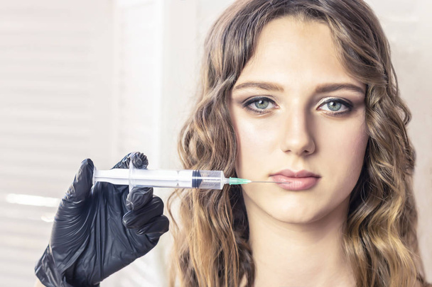 krásná dívka drží injekční stříkačky. Koncepce služeb krásy, Botox, péče o pleť, moderní móda - Fotografie, Obrázek