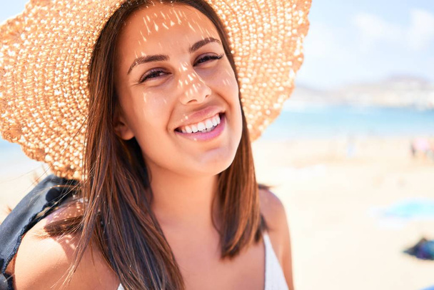 Красива молода жінка, що йде на пляжній набережній насолоджуючись видом на океан, посміхаючись щасливо на літніх канікулах
 - Фото, зображення