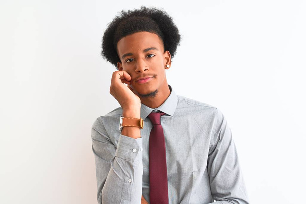 Νεαρός Αφροαμερικάνος επιχειρηματίας με γραβάτα στέκεται πάνω από απομονωμένο λευκό φόντο σκέφτεται κουρασμένος και βαριέται με προβλήματα κατάθλιψης με σταυρωμένα χέρια. - Φωτογραφία, εικόνα