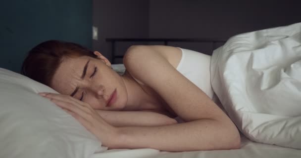 Gyönyörű vöröshajú nő ébredés nélkül hangulat hangulatos ágyban. - Felvétel, videó
