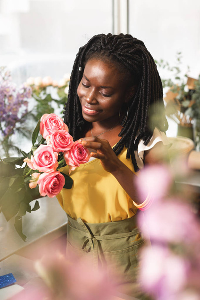 Leuke internationale vrouwelijke persoon genieten van mooie rozen - Foto, afbeelding