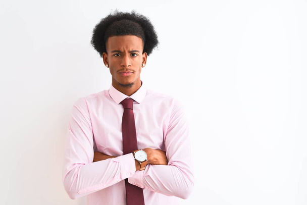 Mladý africký americký obchodník v kravatě, stojící nad osamělým bílým pozadím, skeptický a nervózní, nesouhlasící výraz na tváři se zkříženýma rukama. Negativní osoba. - Fotografie, Obrázek