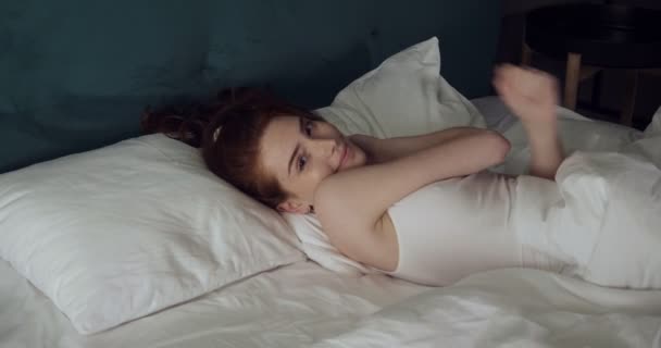 Pretty woman inviting to come and lying on bed. - Filmmaterial, Video
