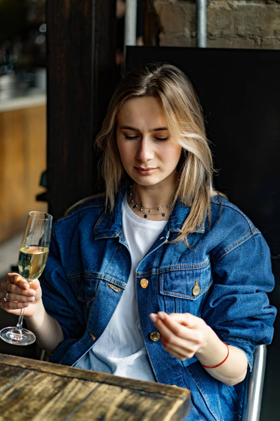 Young beautiful woman in a cafe, a woman drinking champagne in a - Fotó, kép