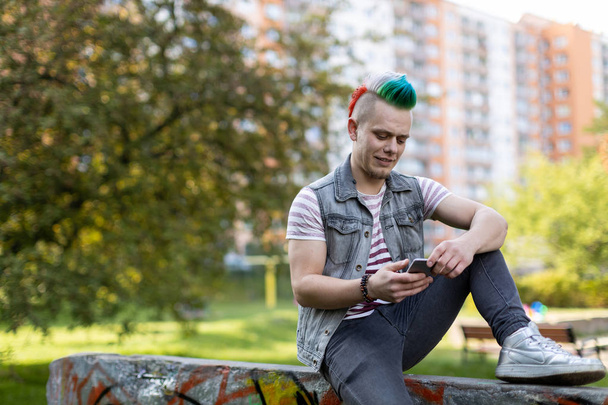 Young punk man with smart phone - Fotó, kép