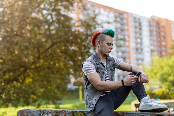 Молодий панк чоловік зі смартфоном
 - Фото, зображення