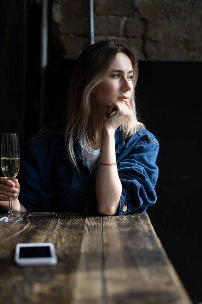 Young beautiful woman in a cafe, a woman drinking champagne in a - Foto, Bild