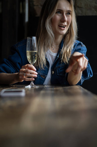 Young beautiful woman in a cafe, a woman drinking champagne in a - Foto, imagen