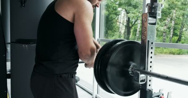 Athlete prepare barbell for exercise in gym - Materiał filmowy, wideo