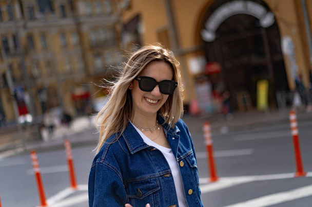 Young beautiful woman walks around the city in Europe, street photo, female posing in the city center - Zdjęcie, obraz