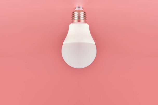 Энергосберегающая лампочка, копировальное пространство, розовый фон. Минимальная концепция идеи
. - Фото, изображение