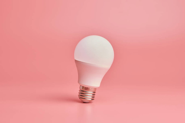 Light bulb, copy space. Energy saving minimal idea concept.Pink background. - Valokuva, kuva