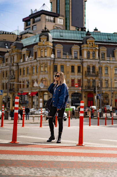 Young beautiful woman walks around the city in Europe, street photo, female posing in the city center - Фото, изображение