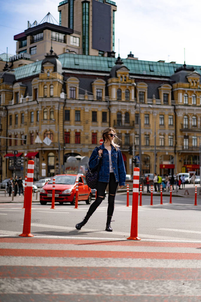 Young beautiful woman walks around the city in Europe, street photo, female posing in the city center - Foto, afbeelding