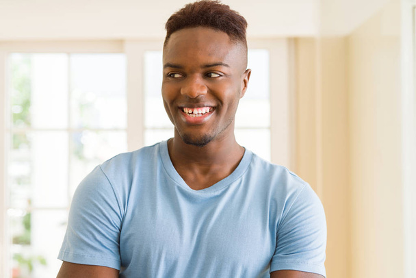 Handsome african young man smiling cheerful with crossed arms - Photo, Image