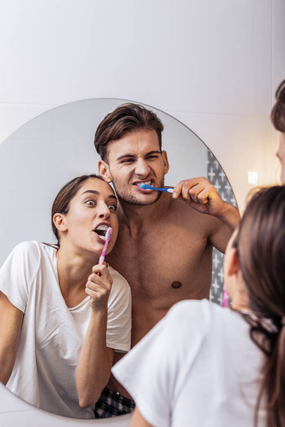 Happy couple taking care of their teeth together - Фото, изображение
