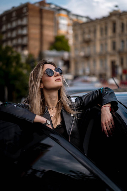 Young beautiful woman sits in a car - Fotografie, Obrázek
