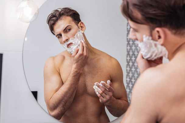 Confident man taking care of his face - 写真・画像