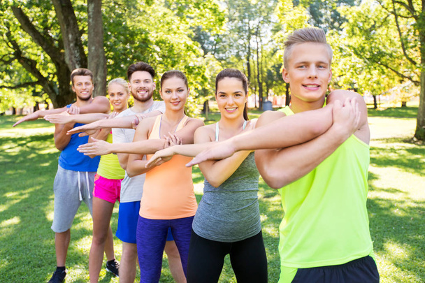 group of happy people exercising at summer park - Photo, image