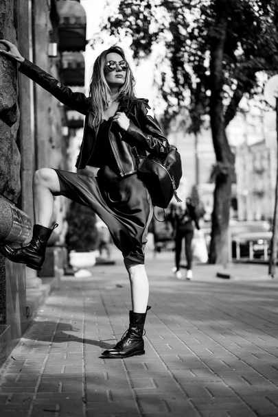 Young beautiful woman walks around the city in Europe, street photo, female posing in the city center - 写真・画像