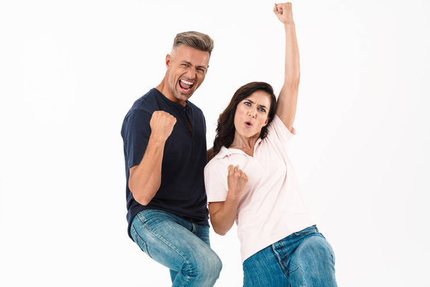 Happy emotional adult loving couple make winner gesture isolated over white wall background. - Foto, afbeelding