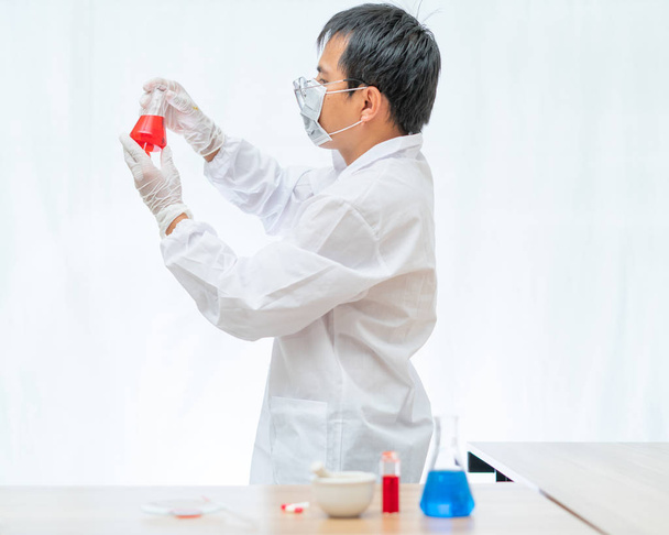Vér fehér izolátumot tartalmazó laboratóriumi palackban lévő üvegben  - Fotó, kép
