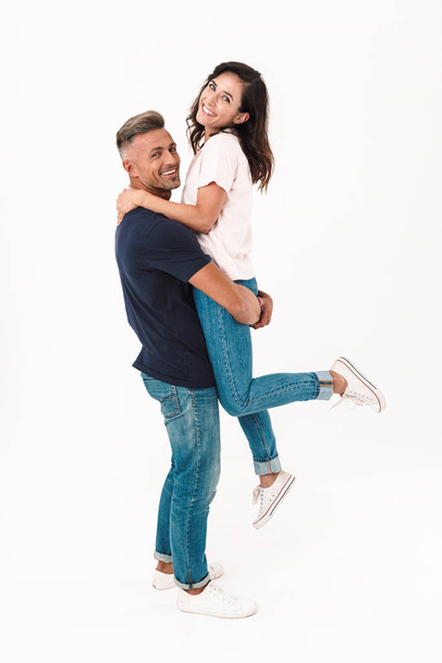 Positive adult loving couple isolated over white wall background having fun. - 写真・画像
