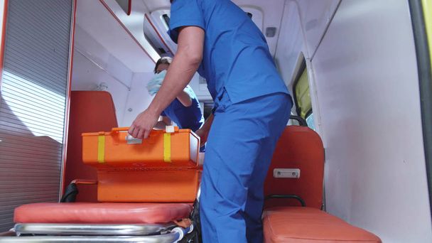 Verpleegster met CORPSMAN in ambulance auto na het werk. - Foto, afbeelding