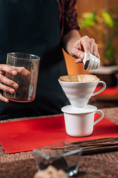 Фільтруй каву. Руки бариста, що вливає мелену каву в ручну кавову крапельницю
 - Фото, зображення