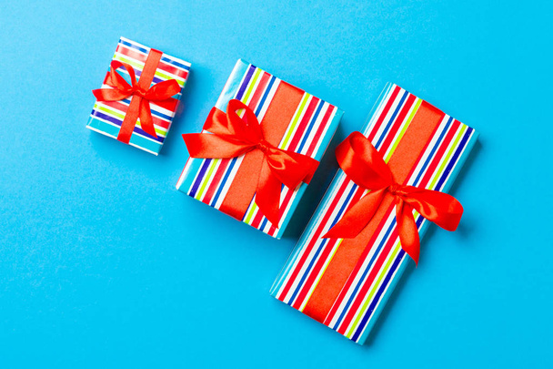Top view karácsonyi ajándék doboz piros íj kék háttér - Fotó, kép