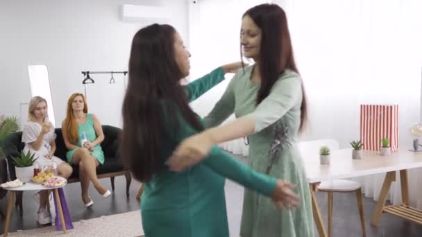Two caucasian women hugging tightly and smiling. Brunette girl embracing her pregnant friend. Female company celebrating pre-birth party. - Záběry, video