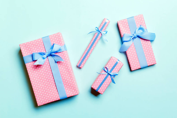 verpackte Weihnachten oder andere Feiertage handgemachtes Geschenk in Papier mit blauem Band auf blauem Hintergrund. Geschenkschachtel, Geschenkdekoration auf farbigem Tisch, Draufsicht - Foto, Bild