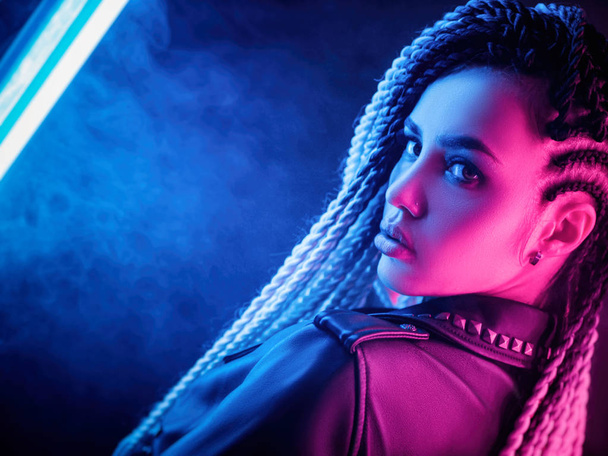 beautiful sexy girl with long dreadlocks posing in neon light - Foto, imagen