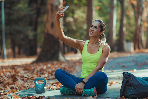 Vrouw maakt Selfie na training buitenshuis - Foto, afbeelding