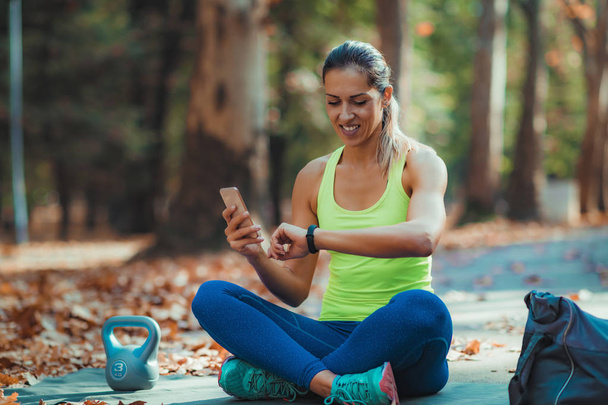 Woman Checking Progress on Smart Watch after Outdoor Training - Foto, Imagen