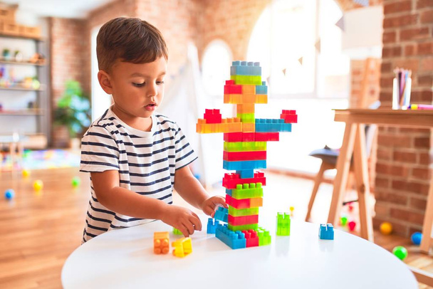 Beau tout-petit garçon jouant avec des blocs de construction à la maternelle
 - Photo, image