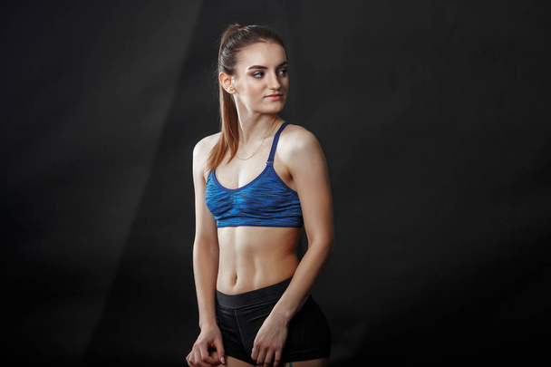 A young sportswoman with ponytail hairstyle in fitness clothes - Zdjęcie, obraz