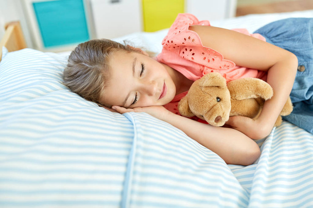 little girl sleeping with teddy bear toy at home - Φωτογραφία, εικόνα