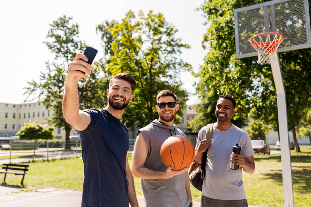 happy men taking selfie at basketball playground - Zdjęcie, obraz