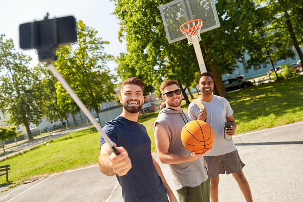 happy men taking selfie on basketball playground - Zdjęcie, obraz